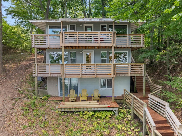 rear view of house featuring stairway and a deck