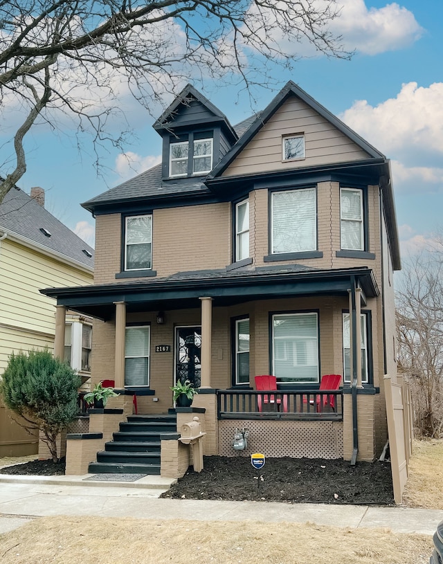 view of front of home with a porch and brick siding