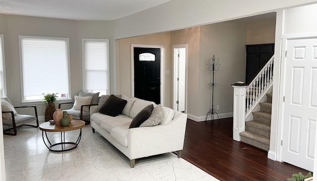 living area with wood finished floors, baseboards, and stairs