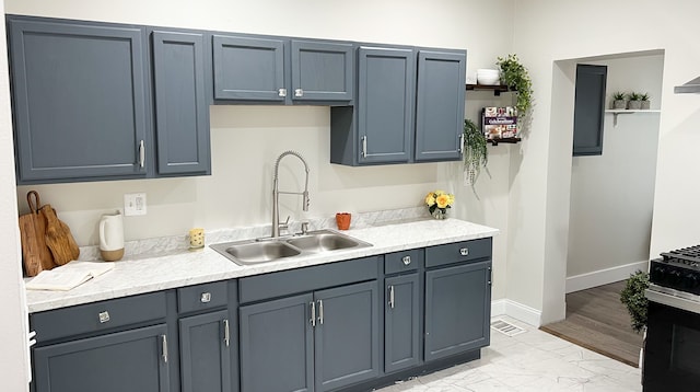 kitchen featuring a sink, baseboards, marble finish floor, light countertops, and open shelves