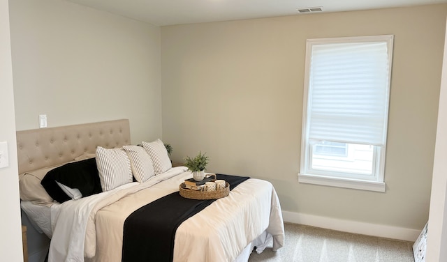 carpeted bedroom with visible vents and baseboards