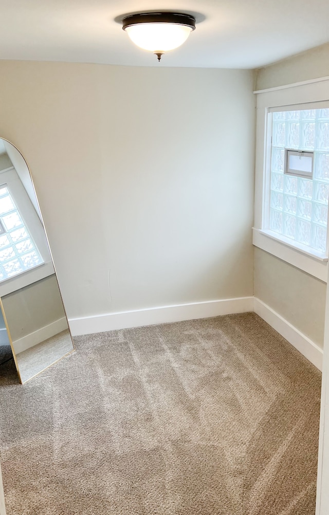 empty room with a healthy amount of sunlight, carpet, and baseboards