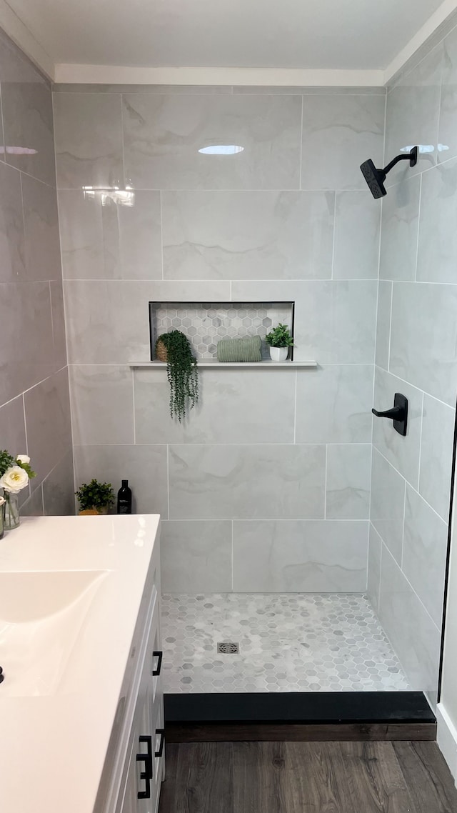 bathroom featuring a tile shower and vanity