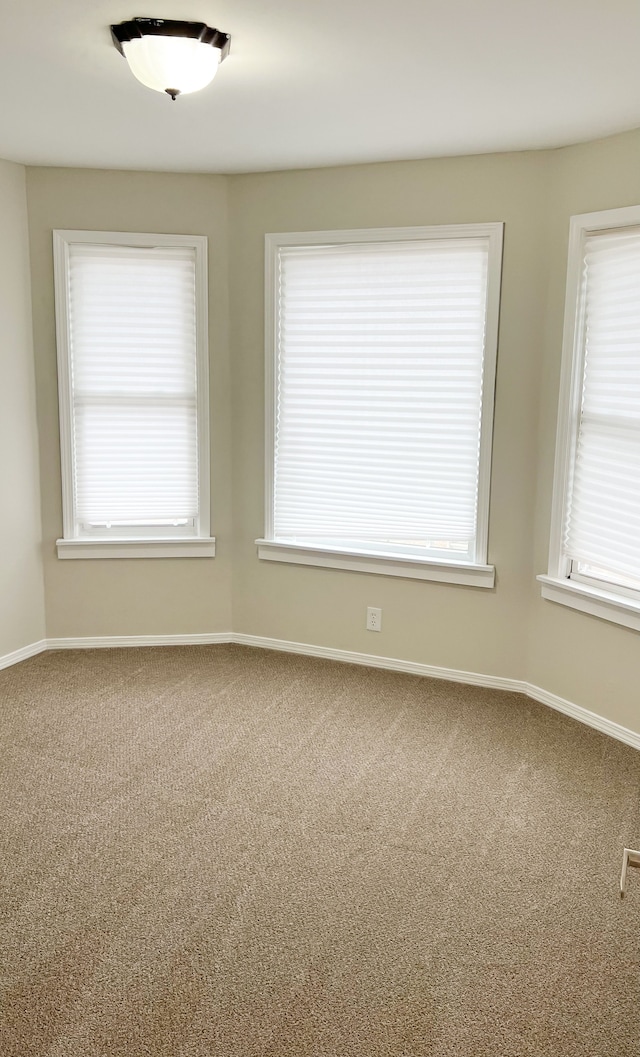 carpeted spare room with baseboards