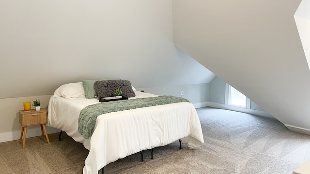 carpeted bedroom with baseboards and vaulted ceiling