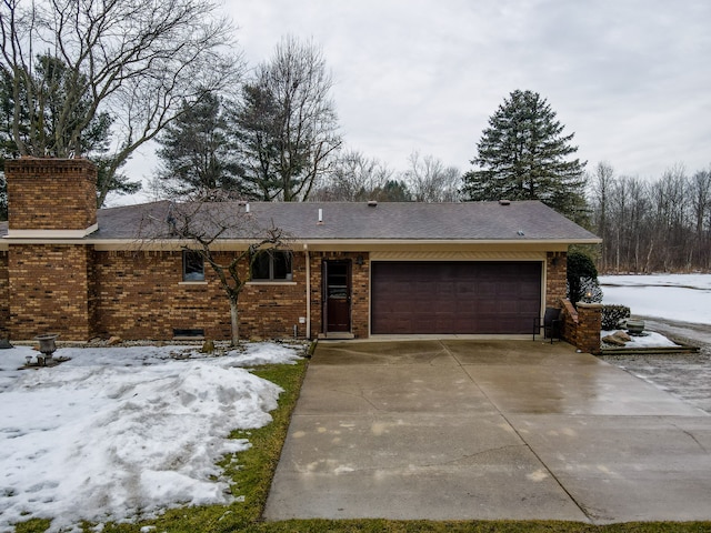 ranch-style house with a garage, driveway, brick siding, and a chimney