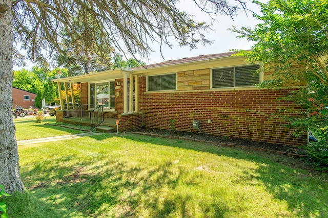 single story home featuring a porch, brick siding, and a front lawn