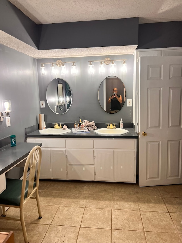 full bath featuring tile patterned flooring, a sink, and a textured ceiling