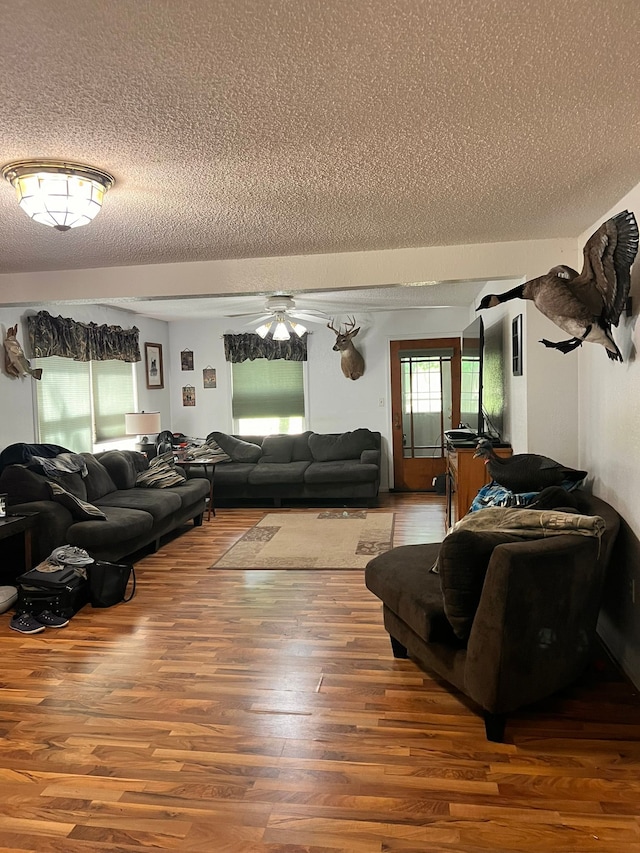 living room featuring a textured ceiling, a ceiling fan, and wood finished floors