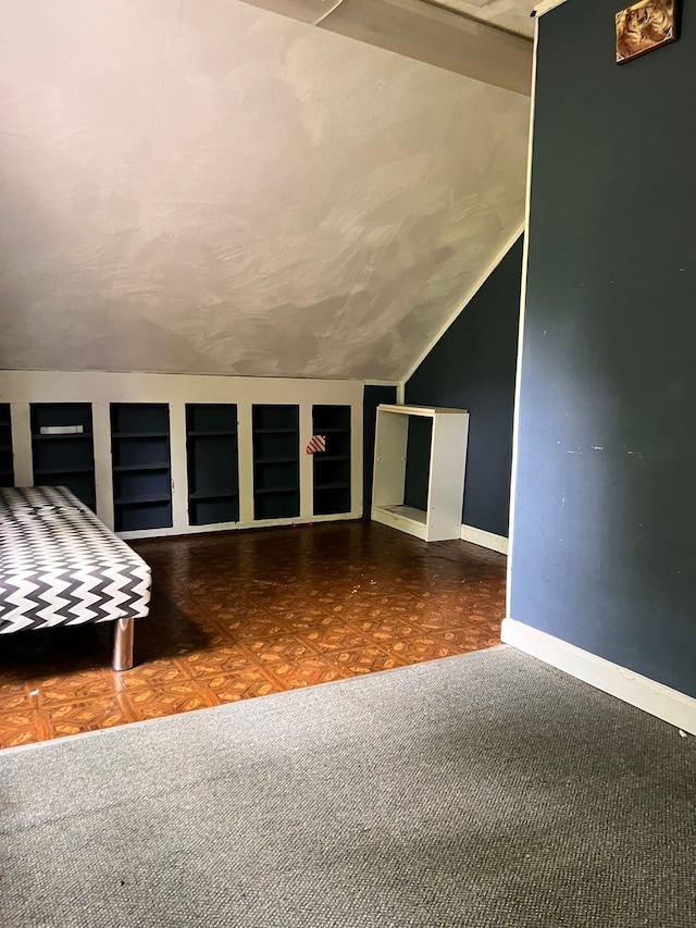 interior space featuring lofted ceiling and baseboards