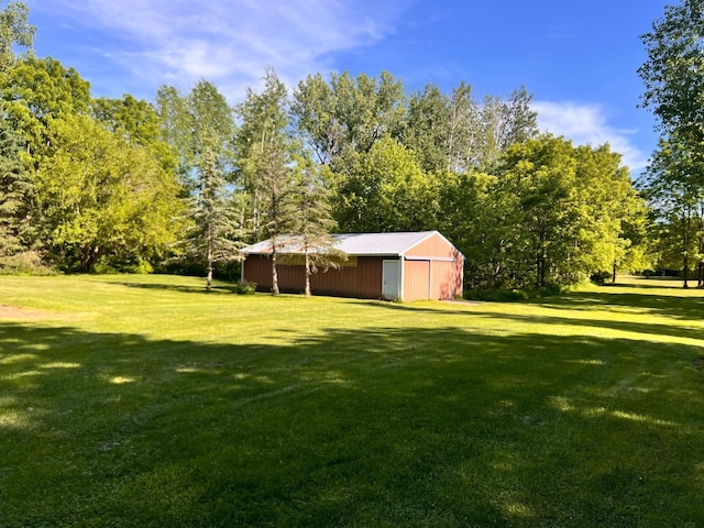 view of yard with an outbuilding, a pole building, and a detached garage