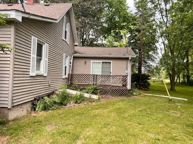 view of side of property with a lawn and a wooden deck