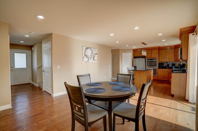 dining area with recessed lighting, baseboards, and wood finished floors