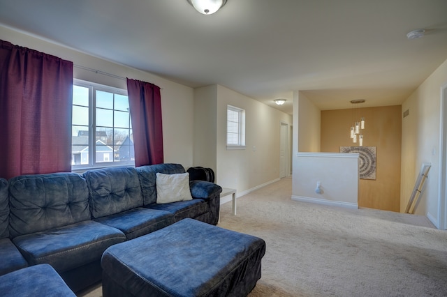 living area with a healthy amount of sunlight, light colored carpet, and baseboards