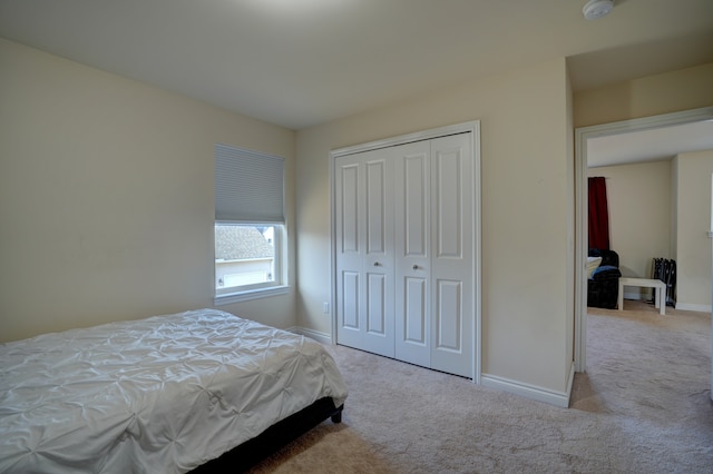 bedroom with a closet, baseboards, and carpet