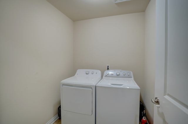 washroom featuring baseboards, independent washer and dryer, and laundry area