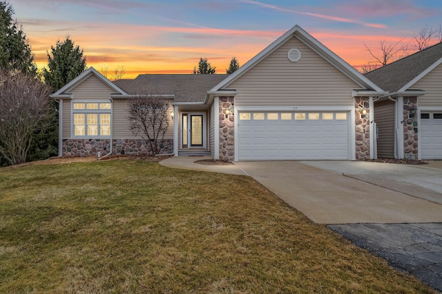 view of front of property with roof with shingles, a yard, an attached garage, stone siding, and driveway