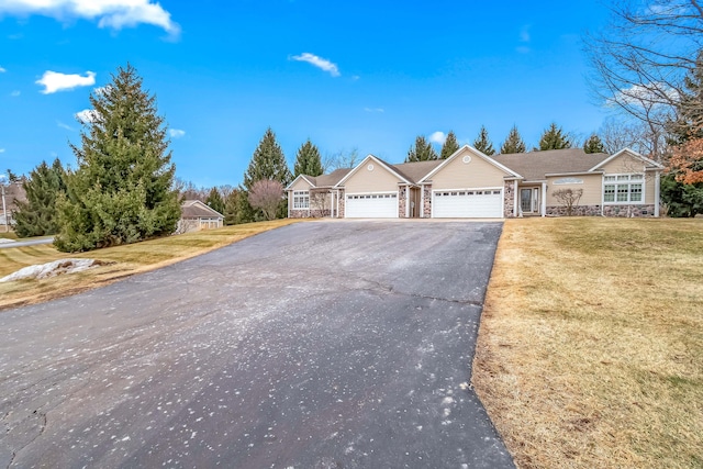 single story home with aphalt driveway, stone siding, a front lawn, and an attached garage