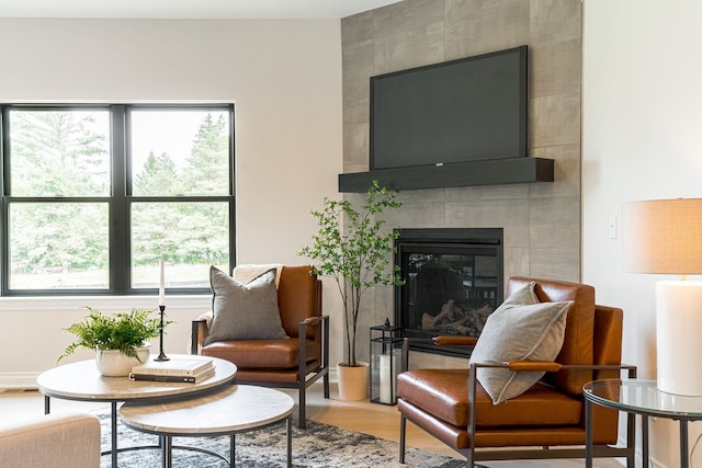 living area with visible vents, a fireplace, and wood finished floors