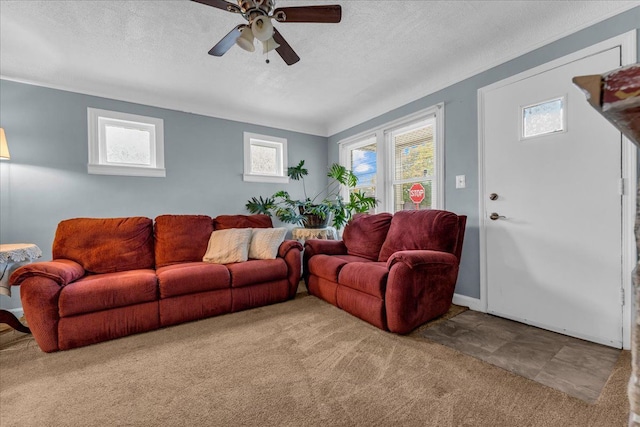 carpeted living area featuring ceiling fan and a textured ceiling