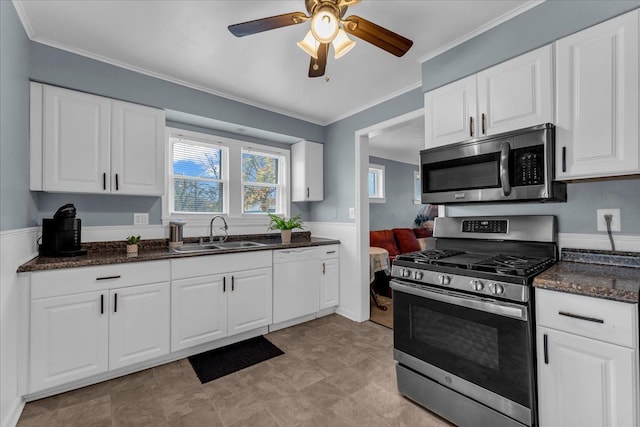 kitchen with a sink, stainless steel appliances, crown molding, and white cabinetry