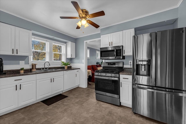 kitchen with a sink, crown molding, white cabinets, and stainless steel appliances