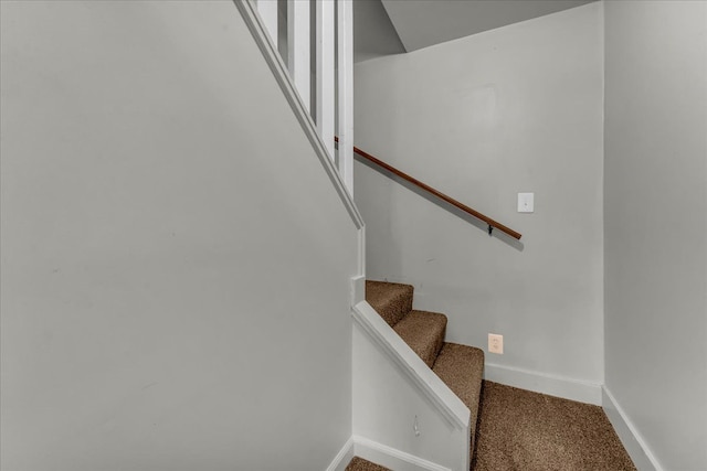 staircase featuring carpet flooring and baseboards