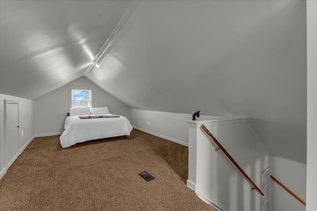 carpeted bedroom with vaulted ceiling, baseboards, and visible vents