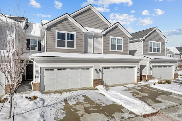 multi unit property with a garage and brick siding