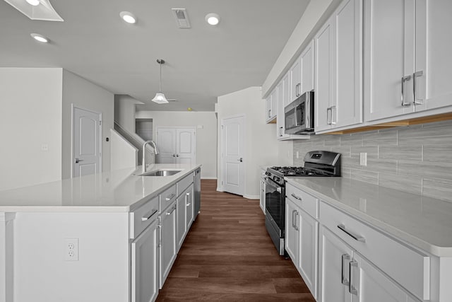 kitchen with visible vents, decorative backsplash, dark wood-style flooring, stainless steel appliances, and a sink