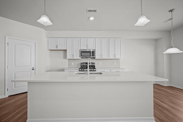 kitchen featuring a sink, visible vents, white cabinets, appliances with stainless steel finishes, and tasteful backsplash