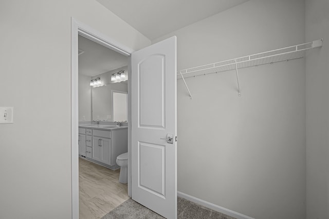 walk in closet featuring a sink