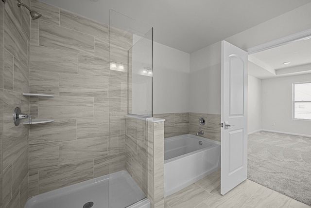 bathroom with a stall shower, a garden tub, and baseboards