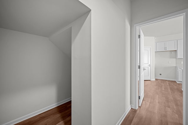 corridor featuring baseboards and light wood-style floors