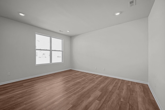 unfurnished room with dark wood-style floors, recessed lighting, visible vents, and baseboards