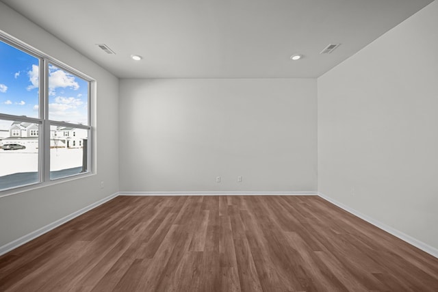 spare room with recessed lighting, visible vents, baseboards, and wood finished floors