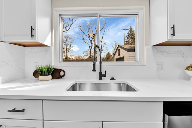 kitchen with white cabinets, a sink, and decorative backsplash