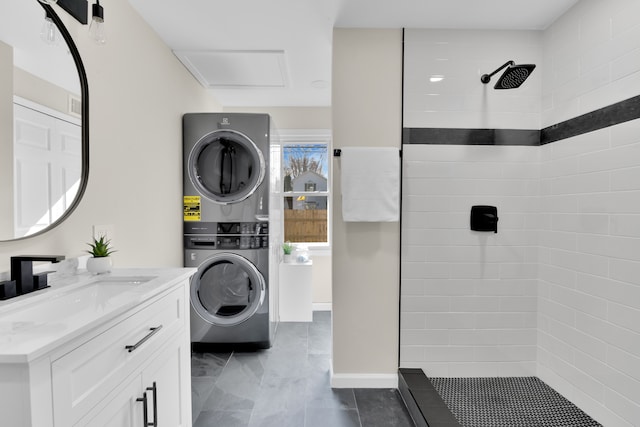 full bath with stacked washer and dryer, tiled shower, and vanity