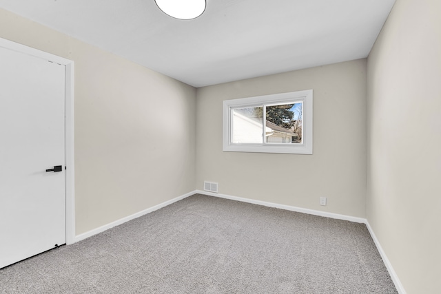 spare room featuring carpet flooring, visible vents, and baseboards