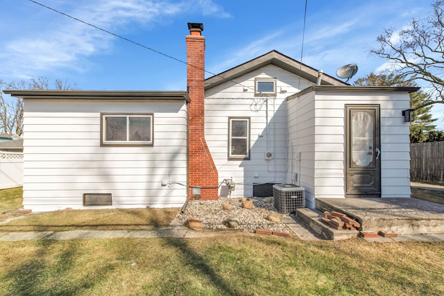 rear view of property with a lawn and fence