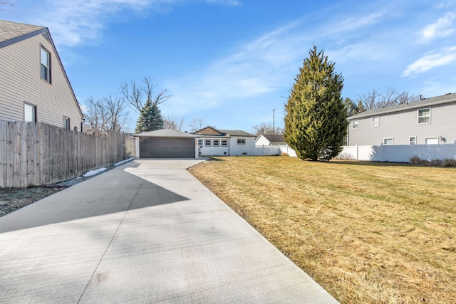 view of front of home with a front yard, an outdoor structure, a detached garage, and fence