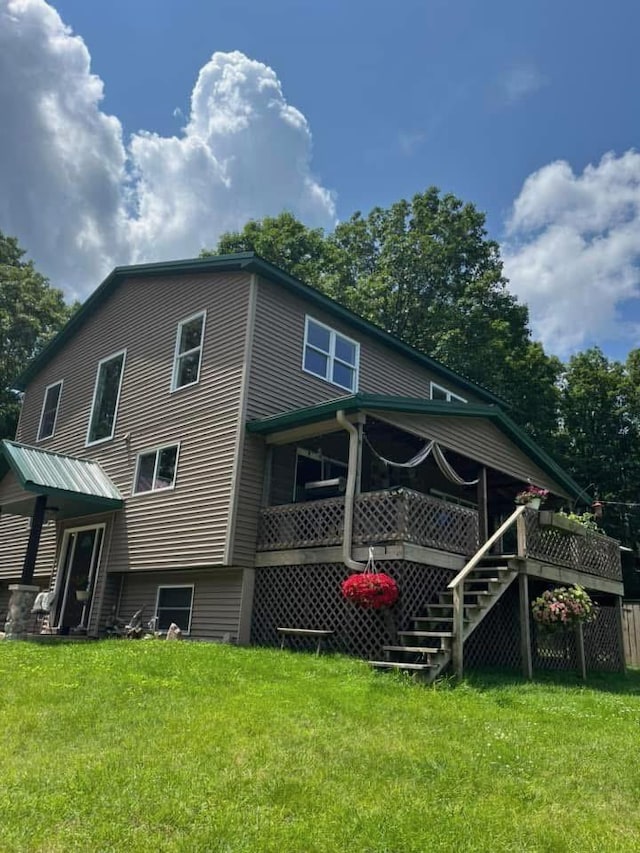 rear view of property featuring a wooden deck, stairs, and a yard