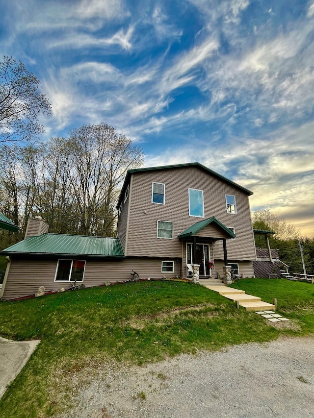 8555 11th Mile, Evart, MI 49631 - rear view of property featuring a yard and a chimney
