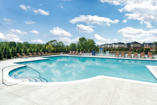 view of swimming pool featuring a patio and fence