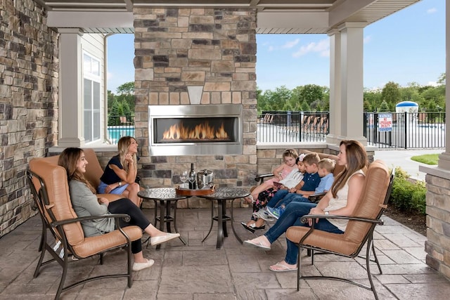 view of patio / terrace featuring fence and an outdoor stone fireplace