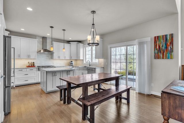 dining space with a chandelier, recessed lighting, light wood-style flooring, and baseboards