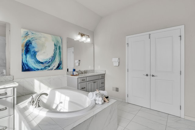 full bathroom with visible vents, vanity, vaulted ceiling, marble finish floor, and a bath