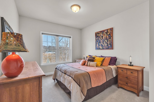 bedroom featuring light carpet and baseboards