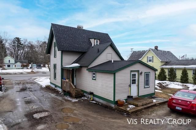 view of front of house featuring roof with shingles and a chimney