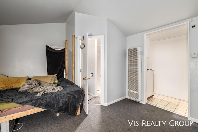 tiled bedroom with carpet floors, a heating unit, and vaulted ceiling